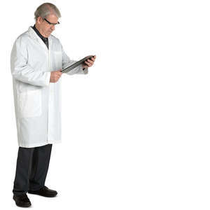 older male doctor standing and reading his notebook