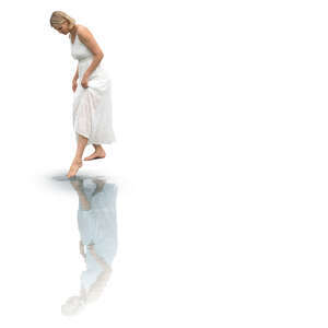 woman in a white dress dipping her foot in the pool