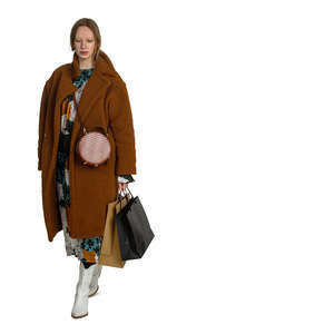 cut out woman in a brown overcoat and with shopping bags walking