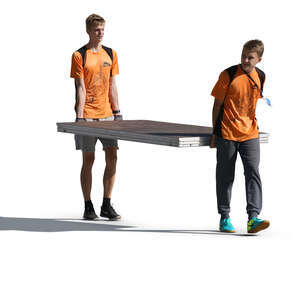 two teenage boys carrying a large table