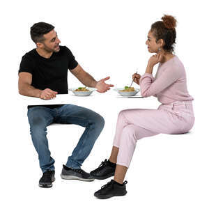 two cut out people sitting in a restaurant and eating