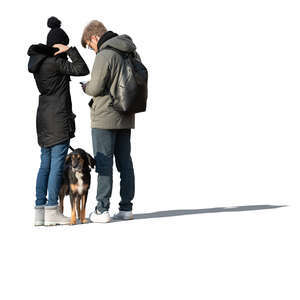 two cut out people with a dog standing in winter