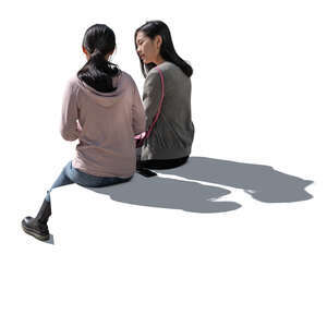 two cut out backlit women sitting and talking