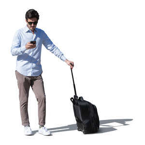 cut out young man with a suitcase standing outside and checking his phone