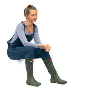 cut out woman in wellies and denim dungarees sitting