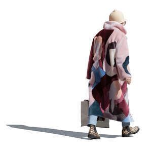 cut out backlit older woman in pink overcoat walking