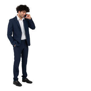 cut out dark haired man in a suit standing and talking on a phone