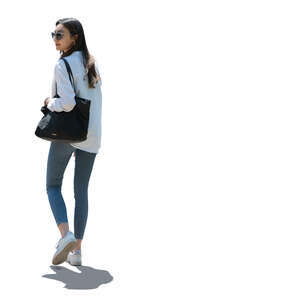 cut out backlit young woman walking and looking back over her shoulder