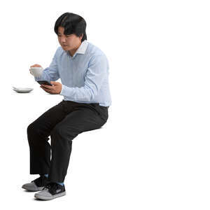 cut out asian man sitting in a cafeteria and drinking coffee