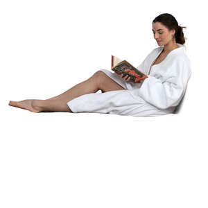 cut out woman in a bathrobe lying on bed and reading a book