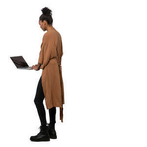 cut out woman standing at a table and working with a laptop