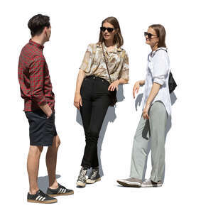 man talking to two girls standing and leaning on a railing