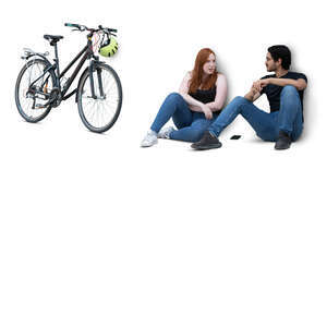 two cut out people sitting on the ground by the wall and talking