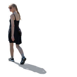 backlit woman in a black summer dress walking