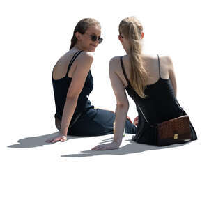 two backlit women sitting and talking seen from back angle