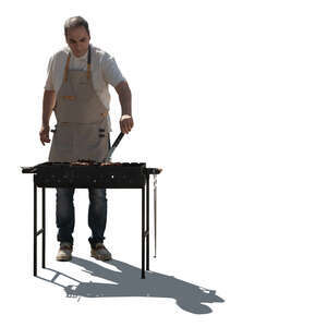 cut out backlit man cooking meat on barbeque grill