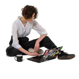 young woman sitting on the ground and working with laptop