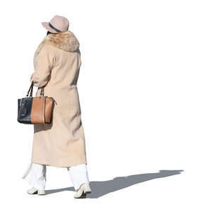 lady in a coat and wearing a hat walking in autumn