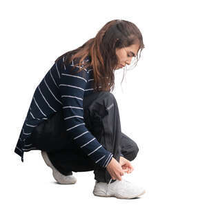 woman squatting and tying her shoe laces