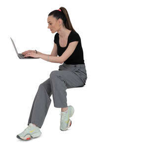 woman sitting at a desk and writing on a laptop