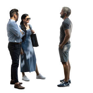 three people staning in partial light and talking