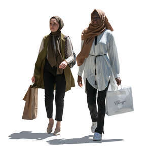 two backlit middle eastern women with shopping bags walking