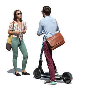 man with a scooter standing and talking to a woman on the street