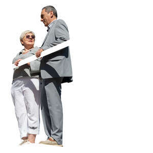 two older people standing up on a balcony and talking