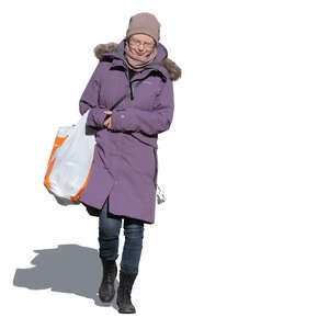 woman with a big bag of groceries walking in winter