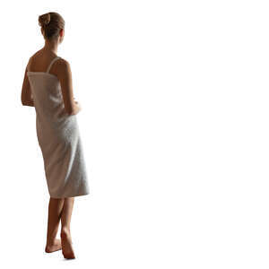 woman in bath towel standing by the window