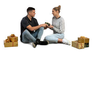 man and woman sitting on the floor and exchanging christmas gifts