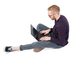 man sitting on the ground and working with a laptop