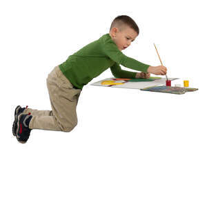 little boy sitting at a table and painting a picture 