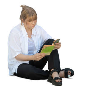 woman sitting on the ground and reading a book