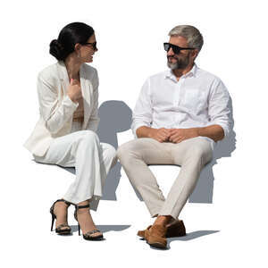 man and woman in white outfits sitting and talking