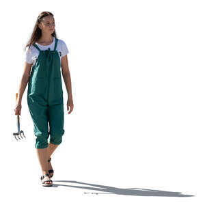 backlit woman in gardening work clothes walking