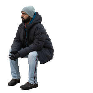indian man in winter jacket sitting