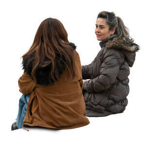 two women wearing warm jackets sitting and talking