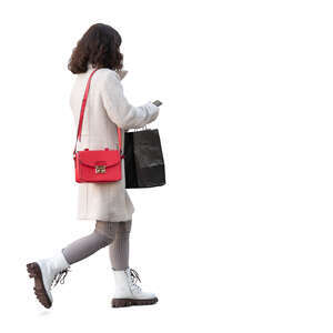 woman with a shopping bag and a phone in hand walking