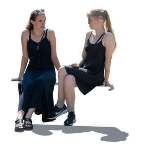 two women in black dresses sitting and talking