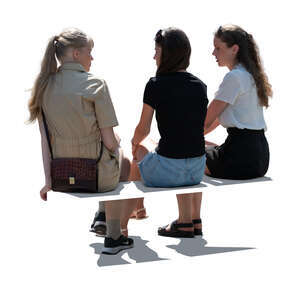 three backlit women sitting and talking