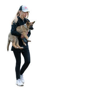 girl walking and carrying a puppy