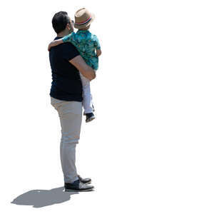 backlit man standing and holding his son in his arms