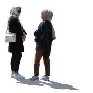 two backlit young muslim women standing and talking