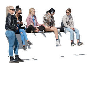 group of teenage girls sitting on a street balustrade