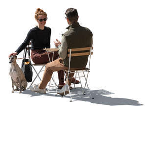 backlit man and woman and a dog sitting in a cafe