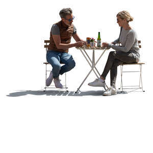 backlit man and woman sitting in an outdoor restaurant