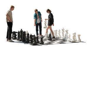 backlit group playing chess in the street
