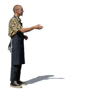 man with apron standing and greeting somebody