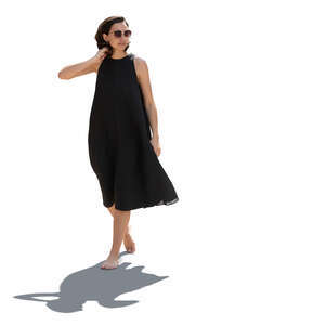 backlit woman in a black dress walking barefoot